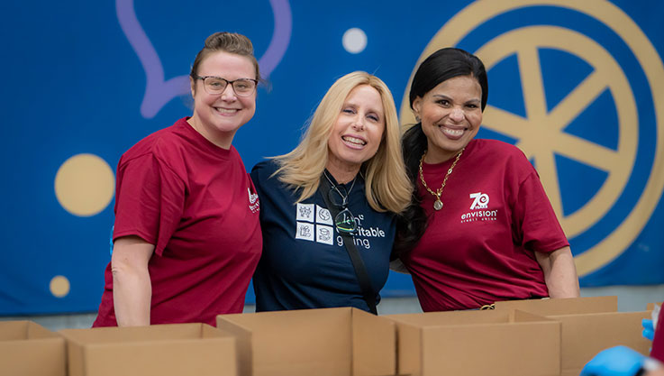 3 volunteers in front of a bright background